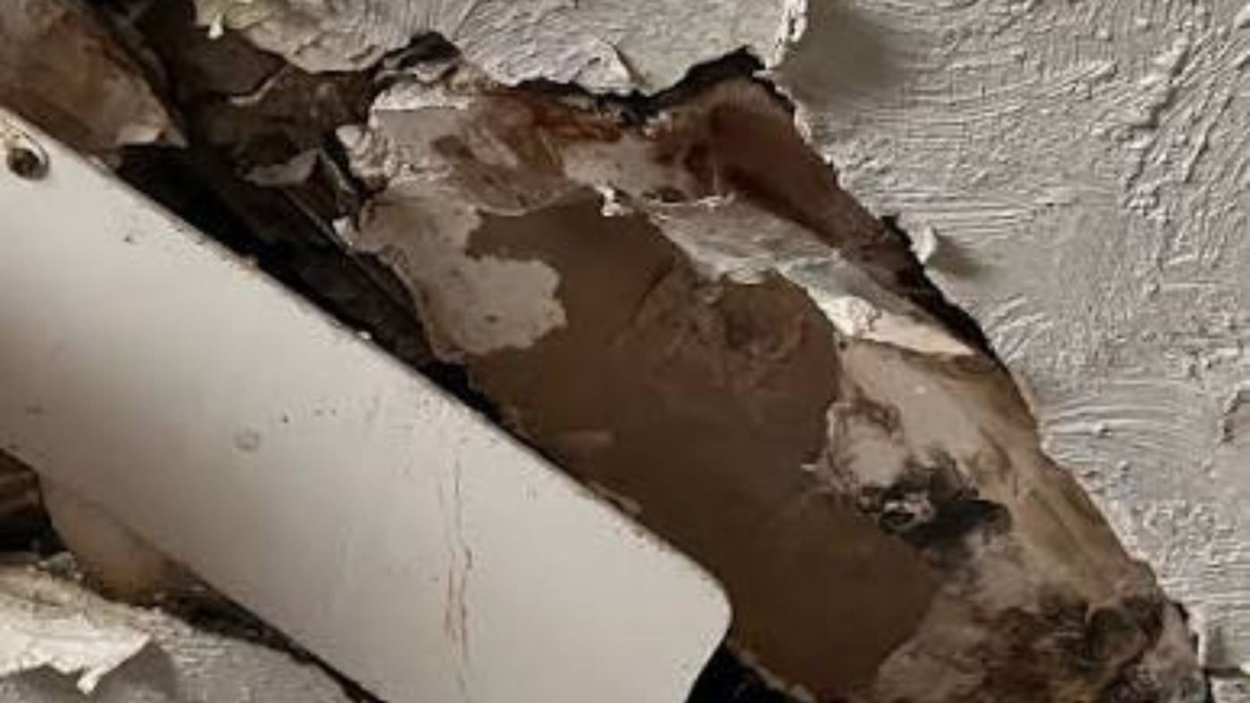 Rotted wood beside a pipe after long-term moisture